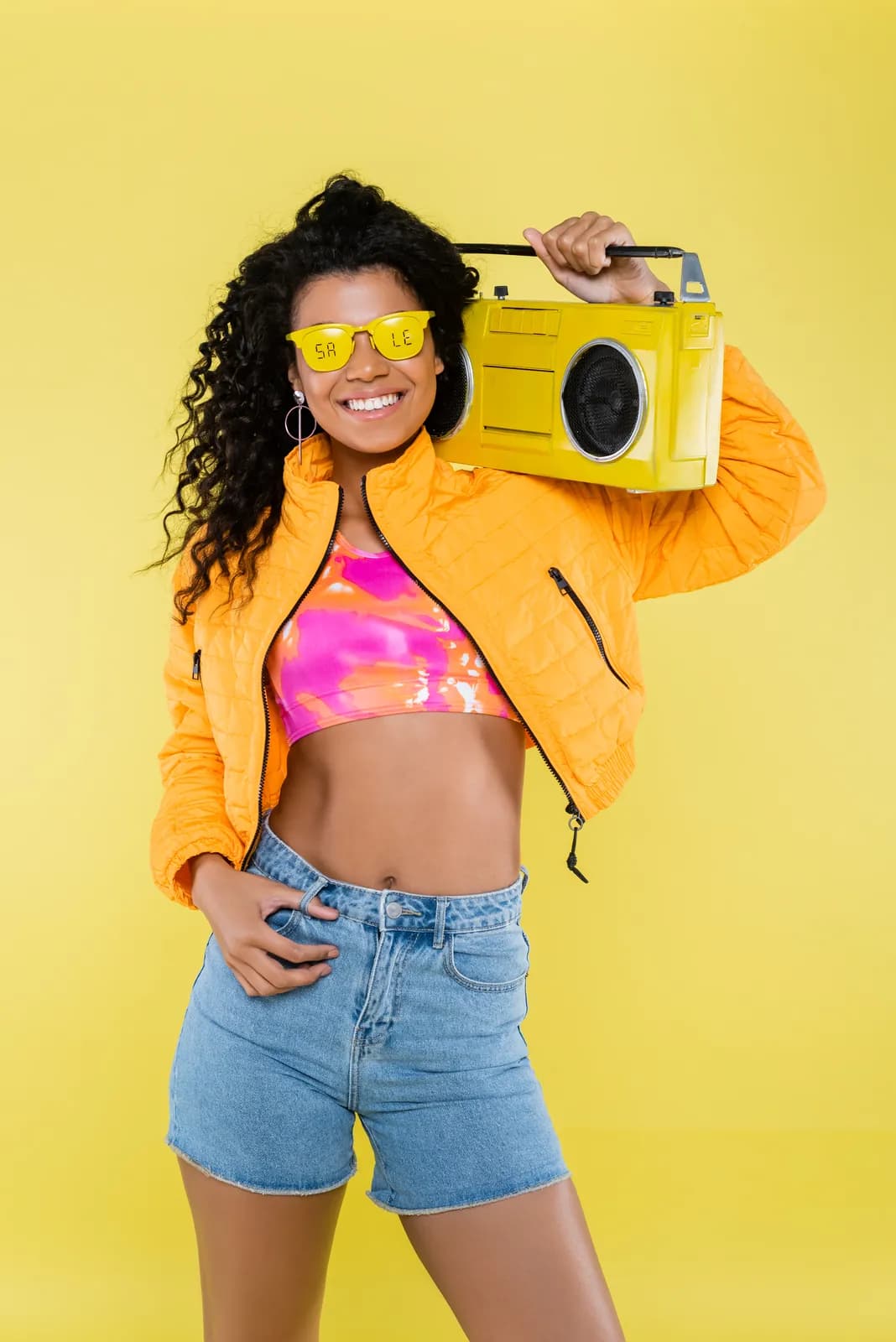 Smiling woman carrying a boombox on her shoulder